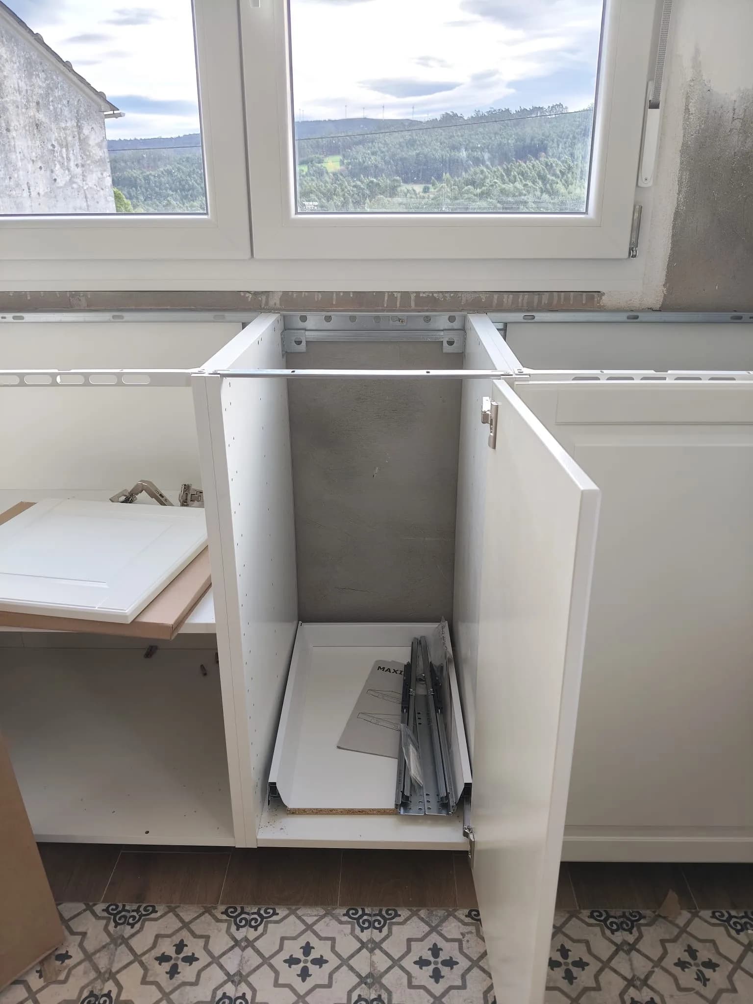 Montaje de muebles de cocina blancos con guías y bisagras durante una mudanza